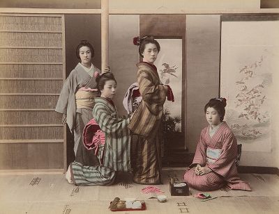 Завязывание пояса оби. Крашенная вручную японская альбуминовая фотография эпохи Мэйдзи (1868-1912). 