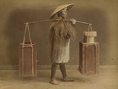Уличный торговец рисовой водкой сакэ. Крашенная вручную японская альбуминовая фотография эпохи Мэйдзи (1868-1912). 